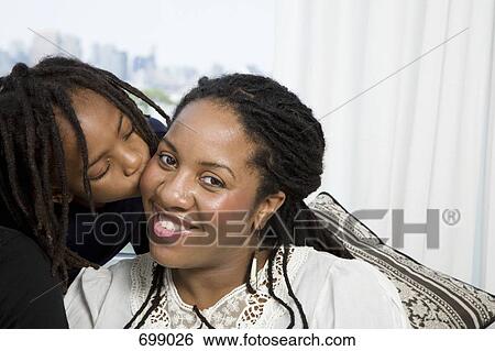 Stock Photograph - A son kissing his mother on the cheek. Fotosearch