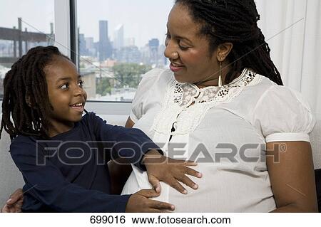 A son touching his mom's pregnant belly View Large Photo Image Stock Photograph - A son touching his mom's pregnant belly. Fotosearch