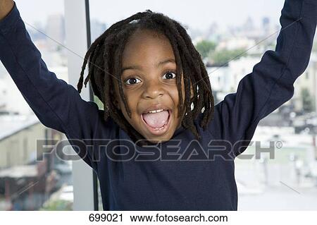 A young boy with his arms raised in excitement View Large Photo Image Stock Image - A young boy with his arms raised in excitement. Fotosearch