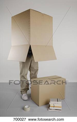 A person standing with a box over his head View Large Photo Image Stock Photo - A person standing with a box over his head. Fotosearch