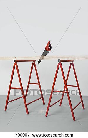 A saw cutting a plank of wood View Large Photo Image Stock Photo - A saw cutting a plank of wood. Fotosearch