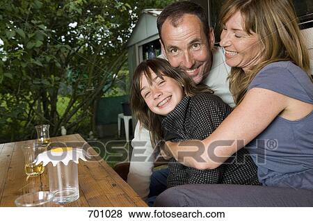 Stock Photo - A family sitting at a table outside of their caravan. Fotosearch