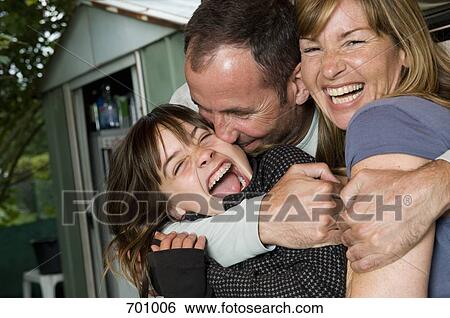 Stock Photograph - A family sitting outside horsing around. Fotosearch