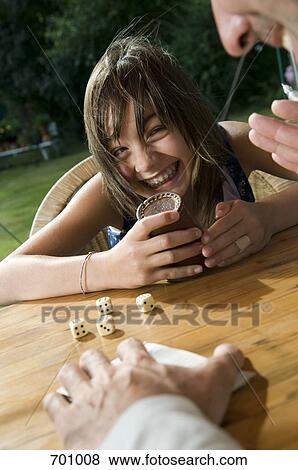 A father and daughter playing a dice game, outdoors View Large Photo Image Stock Photo - A father and daughter playing a dice game, outdoors. Fotosearch