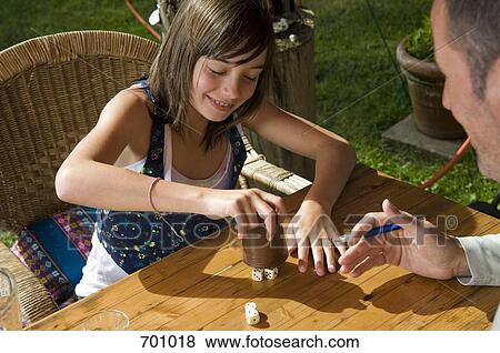 A father and daughter playing a dice game, outdoors View Large Photo Image Stock Photo - A father and daughter playing a dice game, outdoors. Fotosearch