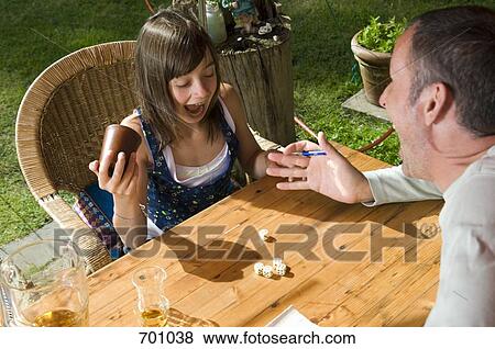 A father and daughter playing a dice game, outdoors View Large Photo Image Stock Photo - A father and daughter playing a dice game, outdoors. Fotosearch