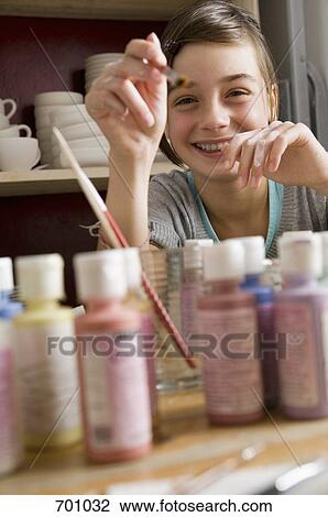 A girl giggling and pointing a paintbrush View Large Photo Image Stock Image - A girl giggling and pointing a paintbrush. Fotosearch