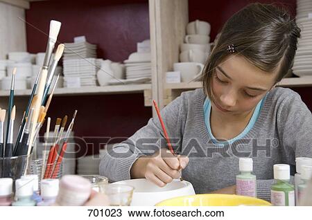 A young girl painting a bowl in a pottery studio View Large Photo Image Stock Image - A young girl painting a bowl in a pottery studio. Fotosearch