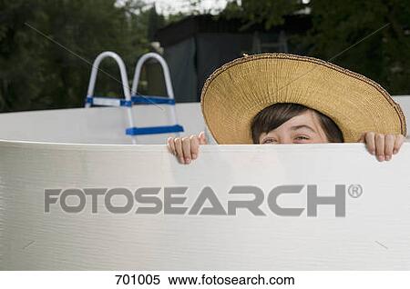 A young girl peaking over the edge of an empty swimming pool View Large Photo Image Stock Photography - A young girl peaking over the edge of an empty swimming pool. Fotosearch