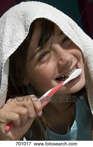 A young girl with a towel over her head, brushing her teeth, outdoors View Large Photo Image Stock Photo - A young girl with a towel over her head, brushing her teeth, outdoors. Fotosearch