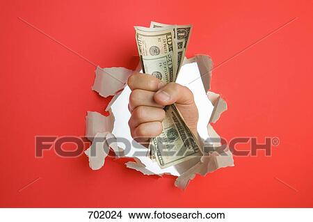 A fist breaking through a wall holding dollar bills View Large Photo Image Picture - A fist breaking through a wall holding dollar bills. Fotosearch