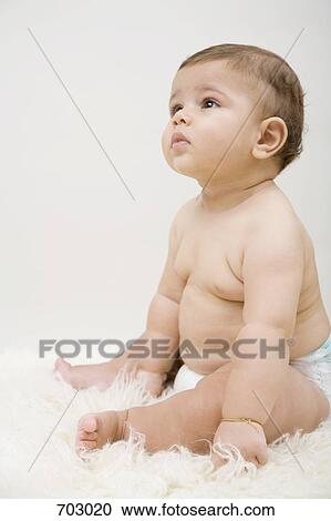 A baby boy sitting on a sheepskin rug View Large Photo Image Stock Image - A baby boy sitting on a sheepskin rug. Fotosearch