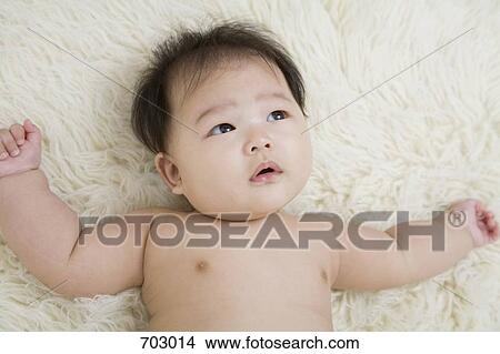 Picture - A baby lying down on a rug. Fotosearch