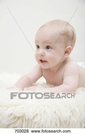 A baby lying on a sheepskin rug View Large Photo Image Stock Photo - A baby lying on a sheepskin rug. Fotosearch