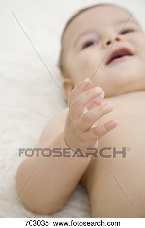 A smiling baby lying down, arm raised View Large Photo Image Stock Photography - A smiling baby lying down, arm raised. Fotosearch