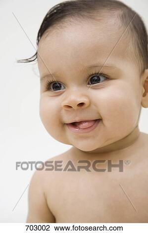 Stock Image - A smiling baby sticking out her tongue, portrait. Fotosearch
