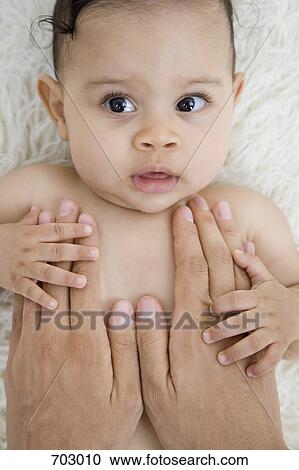 Stock Image - human hands comforting a baby. Fotosearch