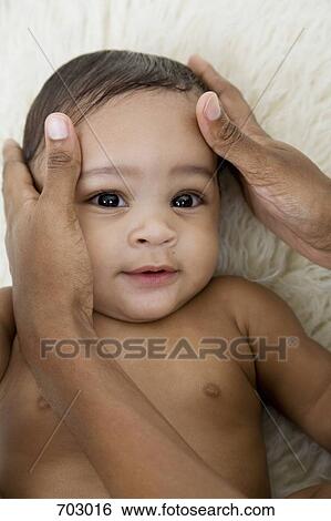 Stock Photograph - human hands comforting a baby. Fotosearch