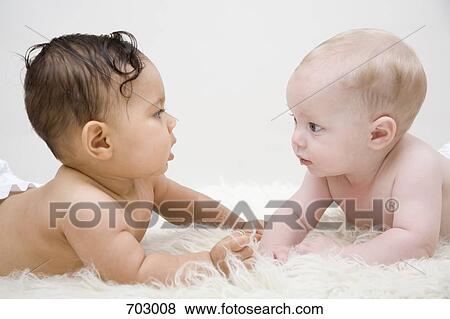 Twos babies staring at each other, lying on front View Large Photo Image Stock Photo - Twos babies staring at each other, lying on front. Fotosearch