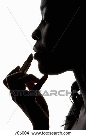 An African American woman applying lipstick, silhouette View Large Photo Image Picture - An African American woman applying lipstick, silhouette. Fotosearch