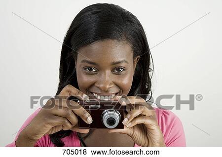 An African American woman preparing to take a photograph View Large Photo Image Stock Photo - An African American woman preparing to take a photograph. Fotosearch