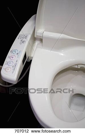 Stock Image - A toilet with remote control on armrest. Fotosearch