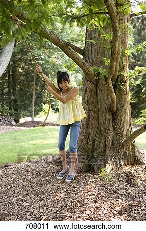A girl preparing to swing on a rope swing View Large Photo Image Stock Image - A girl preparing to swing on a rope swing. Fotosearch