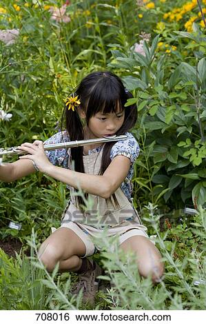 A young girl playing a flute in nature View Large Photo Image Stock Photograph - A young girl playing a flute in nature. Fotosearch