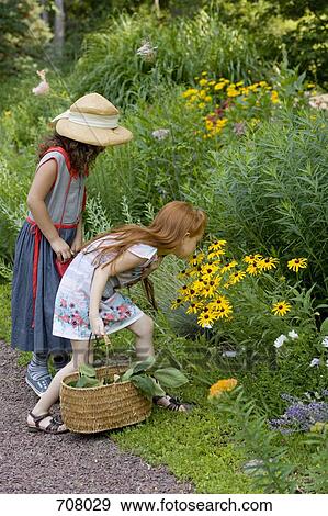 Two girls looking at wildflowers View Large Photo Image Stock Photo - Two girls looking at wildflowers. Fotosearch