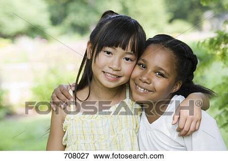 Two girls with their arms around each other, portrait View Large Photo Image Stock Photo - Two girls with their arms around each other, portrait. Fotosearch