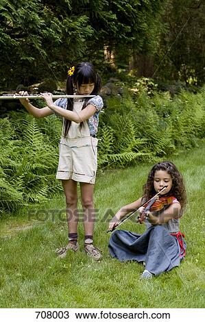 Two young girls playing instruments in nature View Large Photo Image Stock Image - Two young girls playing instruments in nature. Fotosearch