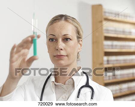 A female doctor preparing a syringe View Large Photo Image Stock Photo - A female doctor preparing a syringe. Fotosearch