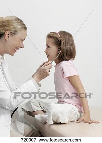 Stock Photo - A female pediatrician letting a girl use her stethoscope. Fotosearch