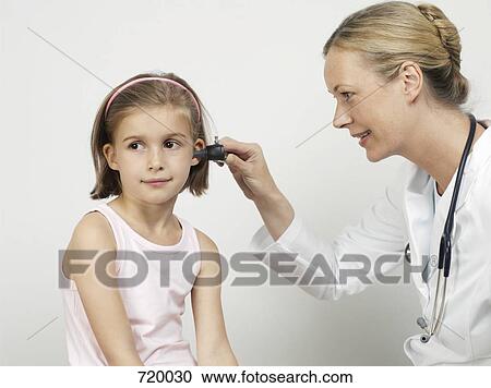 A female pediatrician using an otoscope to exam a girl's ear View Large Photo Image Stock Image - A female pediatrician using an otoscope to exam a girl's ear. Fotosearch