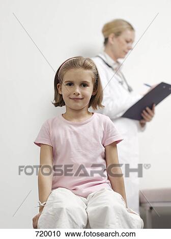 A young girl with a female pediatrician in the background View Large Photo Image Stock Image - A young girl with a female pediatrician in the background. Fotosearch