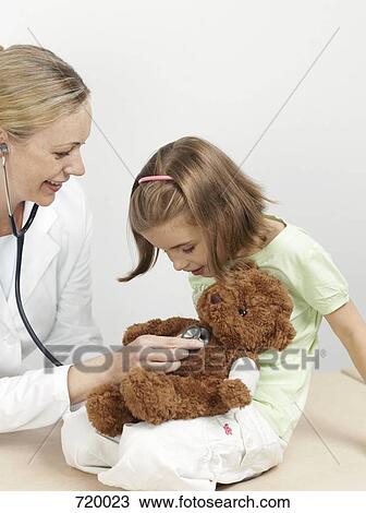 Female pediatrician examining a girl's teddy bear View Large Photo Image Stock Image - Female pediatrician examining a girl's teddy bear. Fotosearch