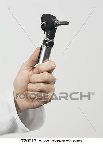 Stock Photo - Human hand holding an otoscope. Fotosearch