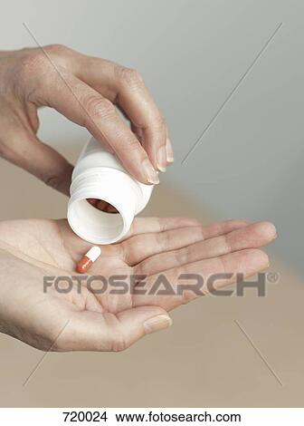 Human hand pouring pill from a pill bottle View Large Photo Image Picture - Human hand pouring pill from a pill bottle. Fotosearch