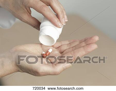 Human hand pouring pills from a pill bottle View Large Photo Image Picture - Human hand pouring pills from a pill bottle. Fotosearch