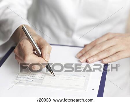 Stock Image - Human hands filling out medical paperwork. Fotosearch