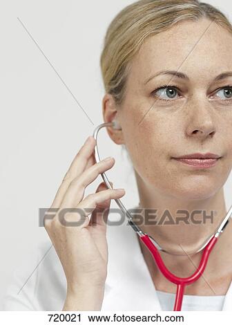 Portrait of a female doctor using a stethoscope, close-up View Large Photo Image Stock Image - Portrait of a female doctor using a stethoscope, close-up. Fotosearch