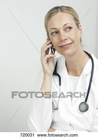 Stock Image - Portrait of a female doctor using a mobile phone. Fotosearch