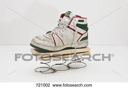 Stock Image - A high top sneaker on a homemade spring. Fotosearch