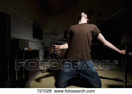 Stock Photo - A man performing air guitar. Fotosearch