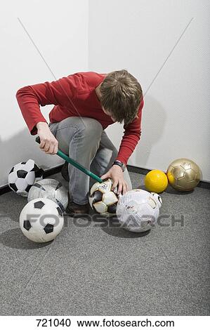 A man pumping up footballs View Large Photo Image Stock Image - A man pumping up footballs. Fotosearch