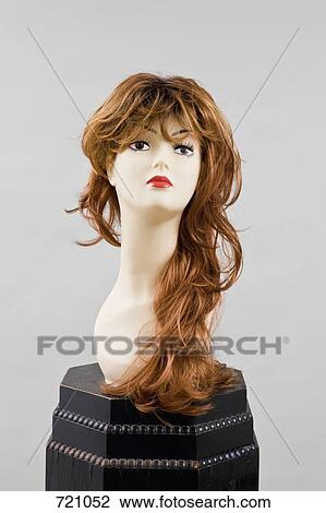 Stock Image - A mannequin head wearing a wig on a pedestal. Fotosearch