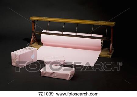 Stock Photo - A roll of wrapping paper and gifts. Fotosearch