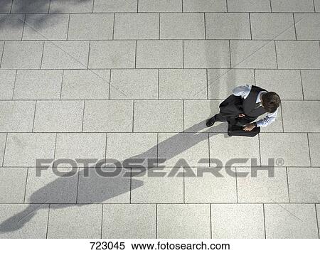 A businessman looking at his watch View Large Photo Image Stock Photography - A businessman looking at his watch. Fotosearch