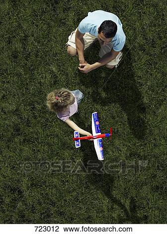 A father a daughter playing with a toy airplane View Large Photo Image Stock Image - A father a daughter playing with a toy airplane. Fotosearch