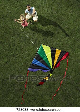 Stock Image - A father and daughter flying a kite together. Fotosearch